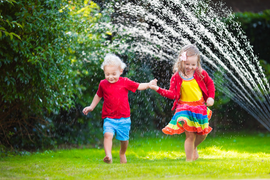 Child playing with garden sprinkler