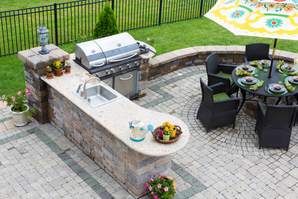 Outdoor kitchen with a griller, dining table, and chairs.